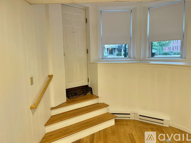 A room with a staircase leading to a door.