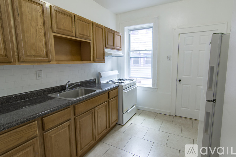 A kitchen with wooden cabinets and a white fridge.