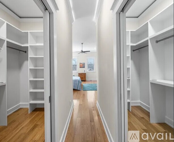 A bedroom with a bed and a fan in the middle of the room.