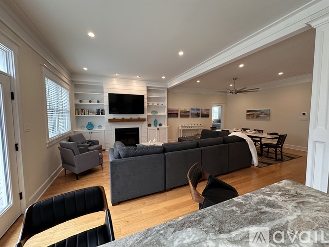 A living room with a grey couch and a fireplace.