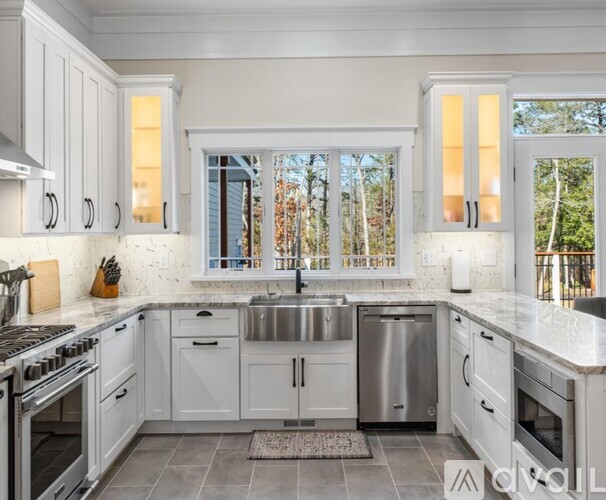 A kitchen with white cabinets and a stainless steel sink.