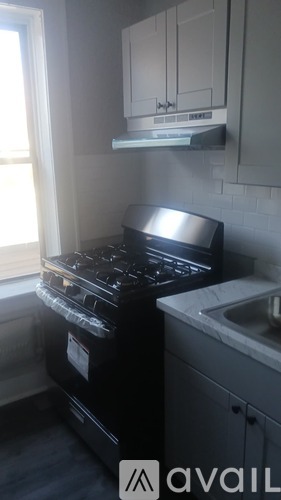 A black stove top oven sits next to a white sink in a kitchen.