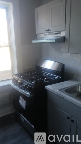 A black stove top oven sits next to a white sink in a kitchen.