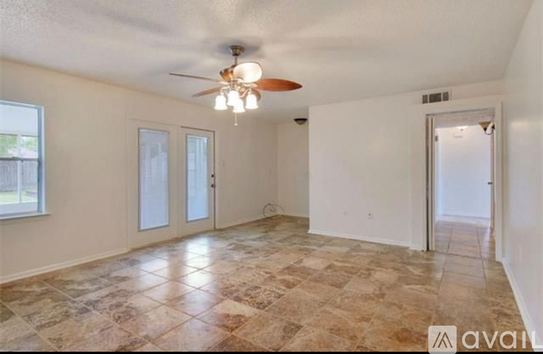 A room with a ceiling fan and tiled floor.