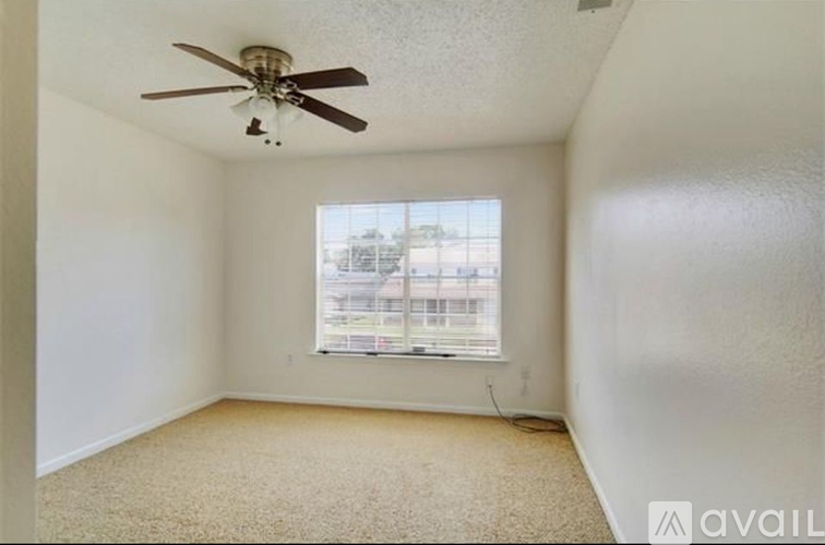 A room with a ceiling fan and carpeted floor.