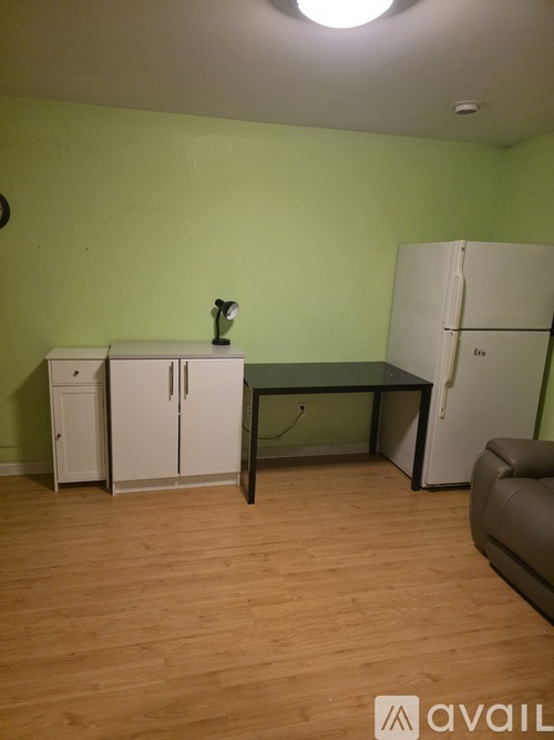A kitchen area with a table, chairs, and a fridge.