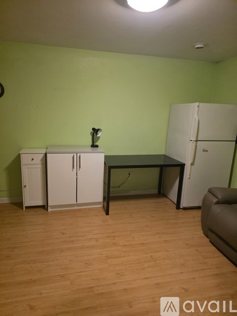 A kitchen area with a table, chairs, and a fridge.
