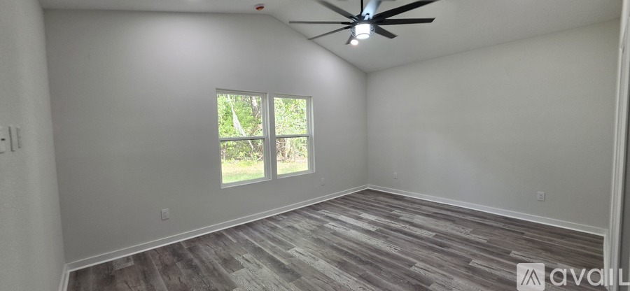 A spacious room with a ceiling fan and a window.