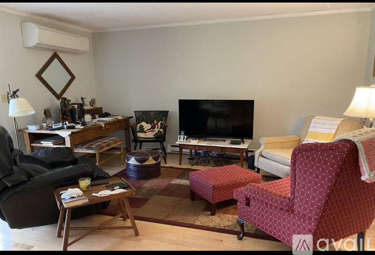 A living room with a red chair and a black couch.