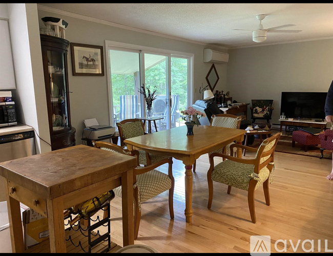 A dining room with a wooden table and chairs.