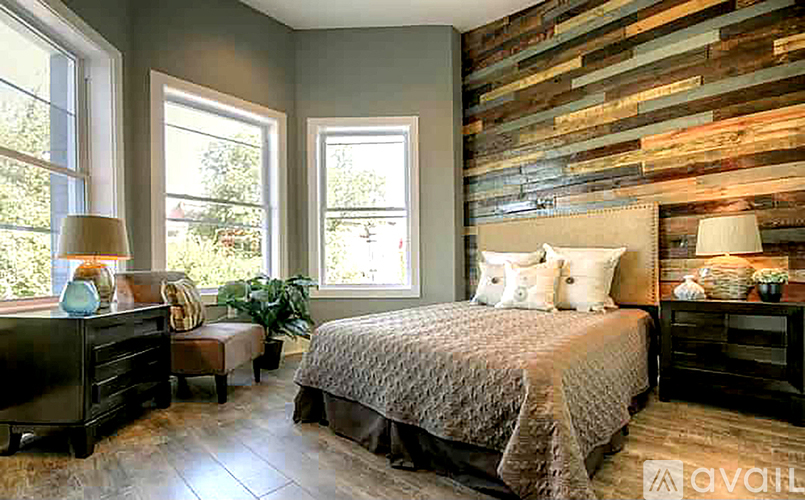 A bedroom with a bed, nightstand, and a window.