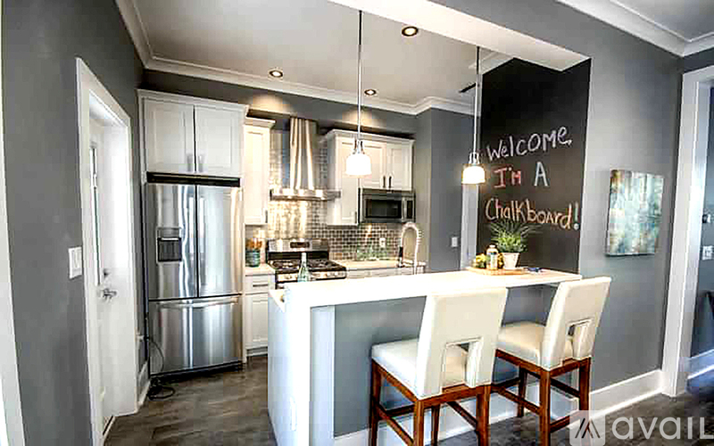 A kitchen with a white island and a welcome sign on the wall.