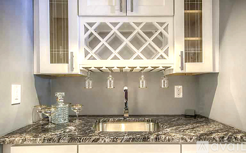 A kitchen with a marble countertop and a sink.