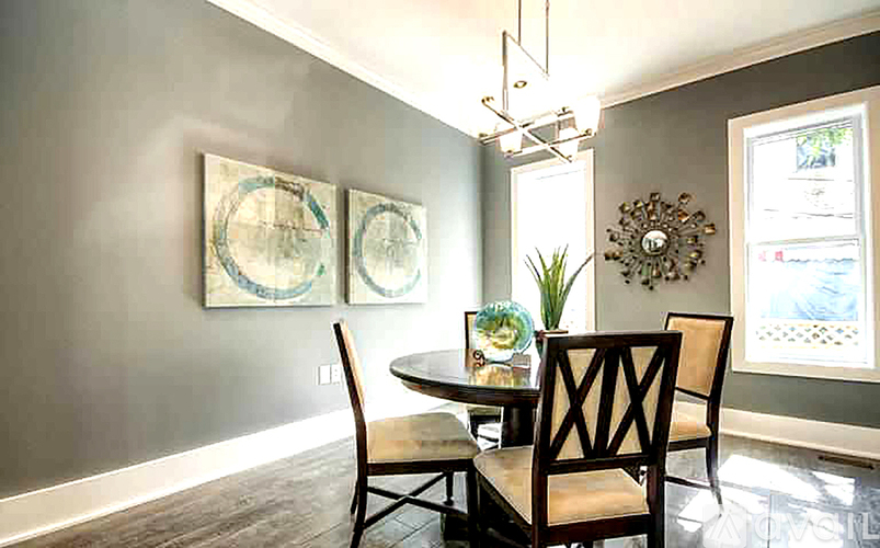 A dining room with a table and chairs.