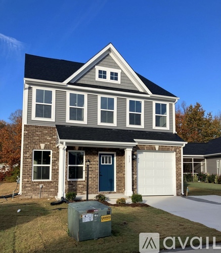 A house with a grey and white exterior and a blue door.