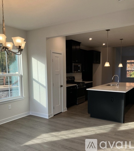 A kitchen with a black counter and a white island.