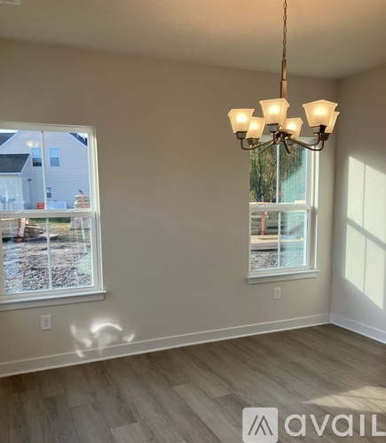 A room with a chandelier and a window overlooking a street.