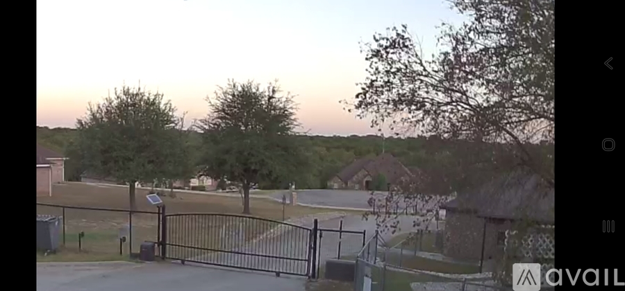A black gate blocks the entrance to a driveway.