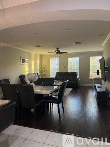 A living room with a black table and chairs.