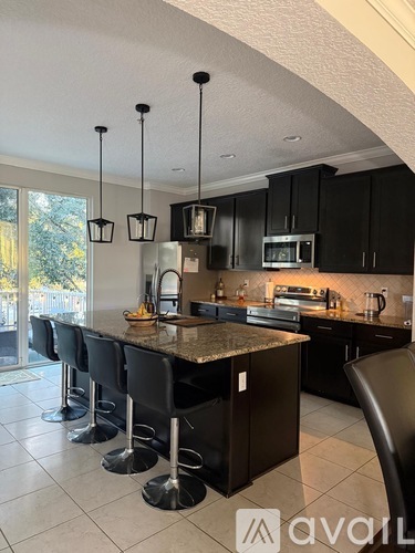 A kitchen with black cabinets and a granite countertop.