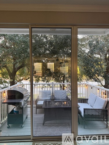 A patio with a table and chairs is visible through a glass door.