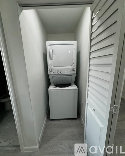A white toilet is installed in a small white room.