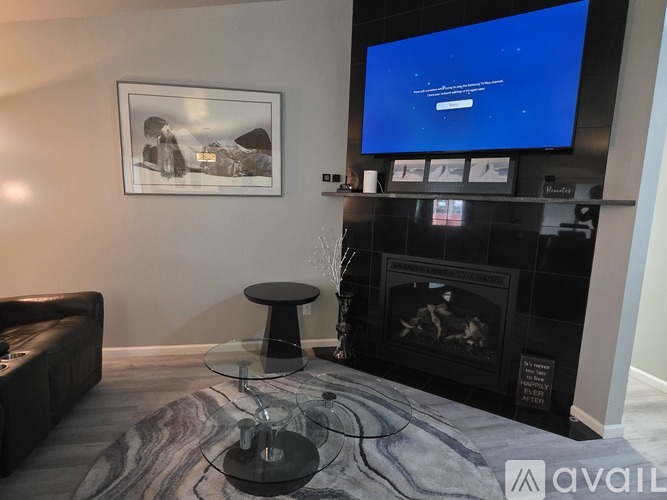 A living room with a fireplace and a television displaying a blue screen.