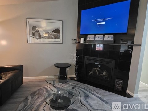 A living room with a fireplace and a television displaying a blue screen.