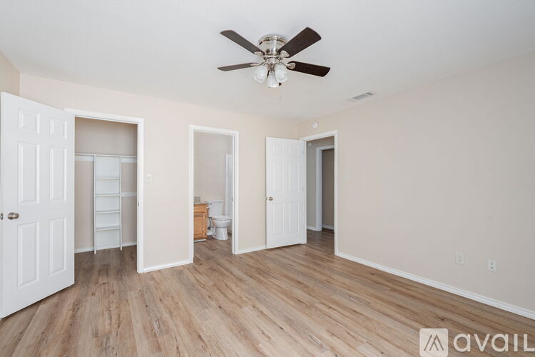 A spacious room with a ceiling fan and wooden flooring.