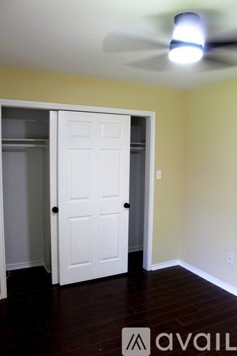 A room with a white door and a ceiling fan.