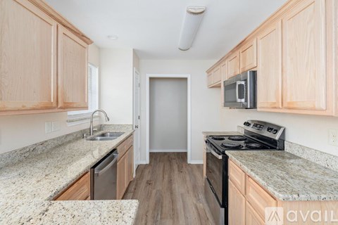 A kitchen with wooden cabinets and granite countertops.