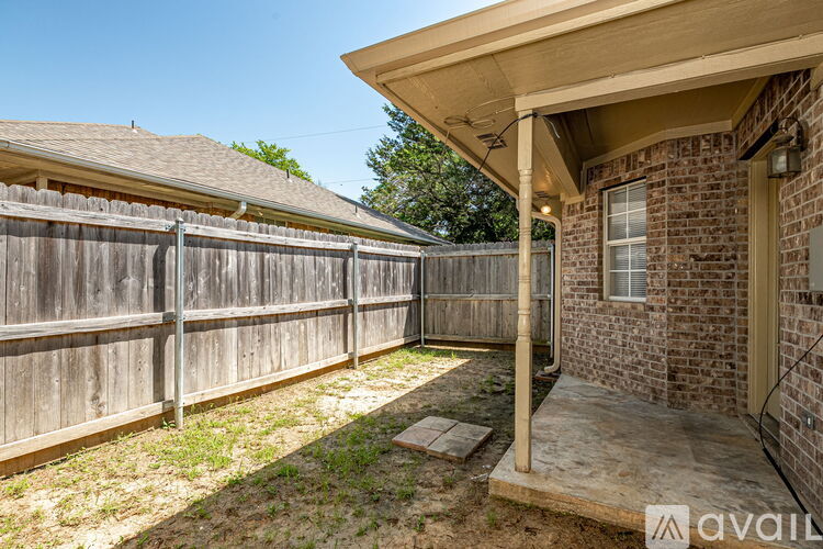 A house with a wooden fence and a covered patio area.