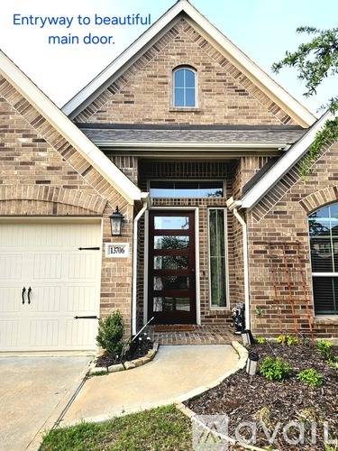 A house with a white garage door and a brick facade.