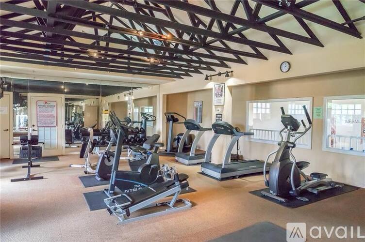 A gym with a variety of exercise equipment including treadmills and stationary bikes.