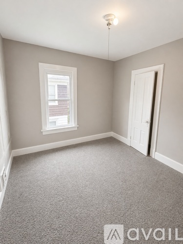 A room with a carpeted floor and a window.