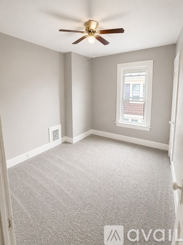 A room with a ceiling fan and a window.