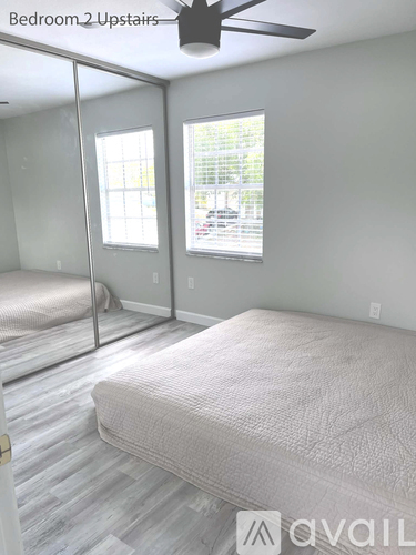 A bedroom with two beds and a ceiling fan.