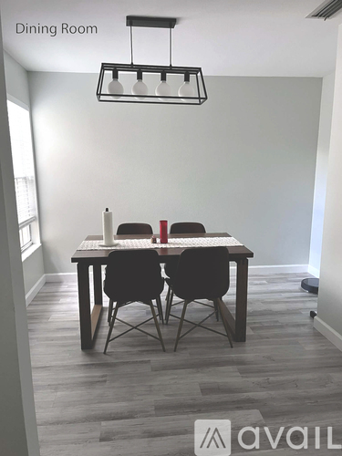 A dining room with a table and chairs.