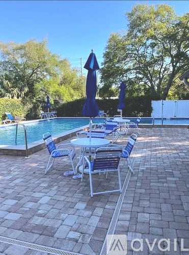 A poolside area with a table and chairs.