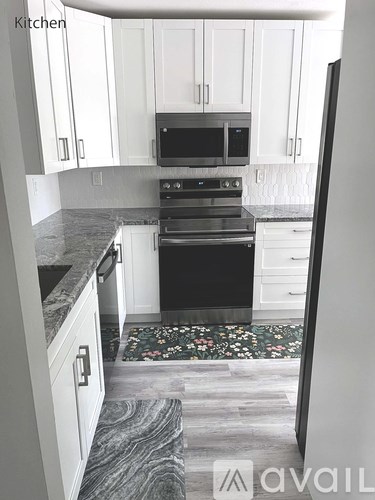 A kitchen with a black oven and white cabinets.