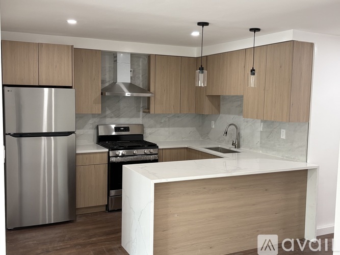 A modern kitchen with wooden cabinets and a stainless steel refrigerator.
