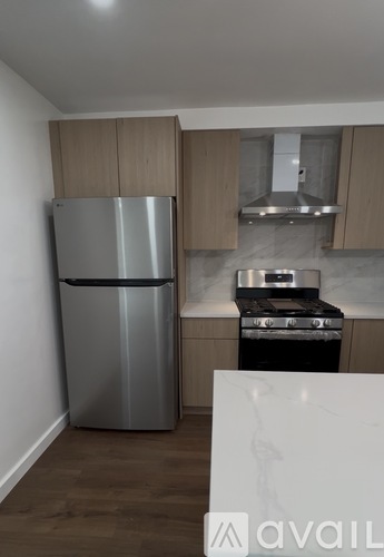A kitchen with a stainless steel refrigerator and a stove top oven.