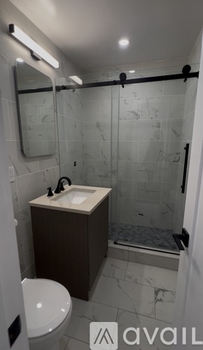 A bathroom with a toilet, sink, and shower.