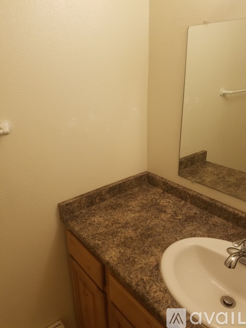 A bathroom with a granite countertop and a white sink.