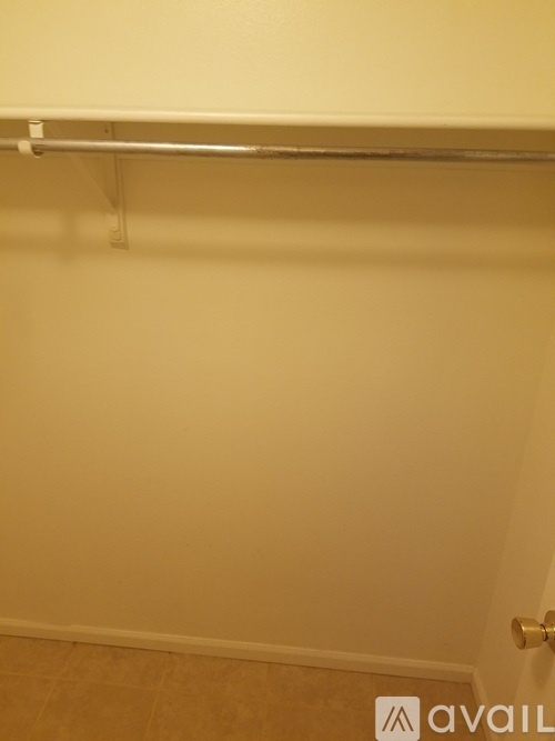 A white wall with a metal rod on top.