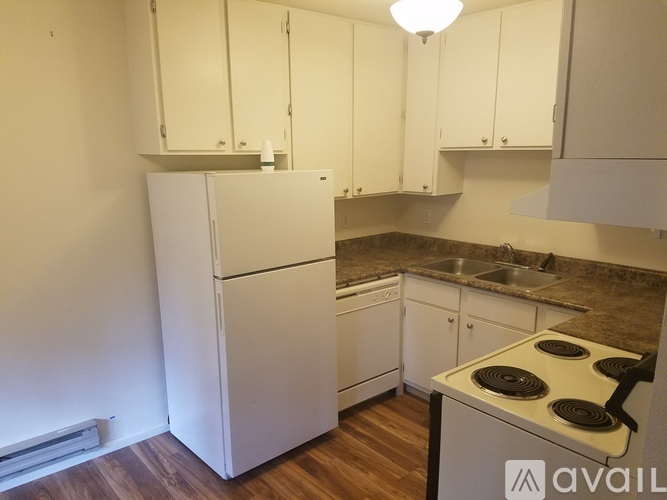 A kitchen with white cabinets and a stove top oven.