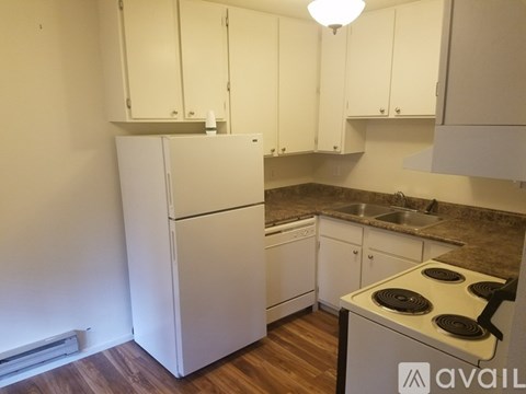 A kitchen with white cabinets and a stove top oven.