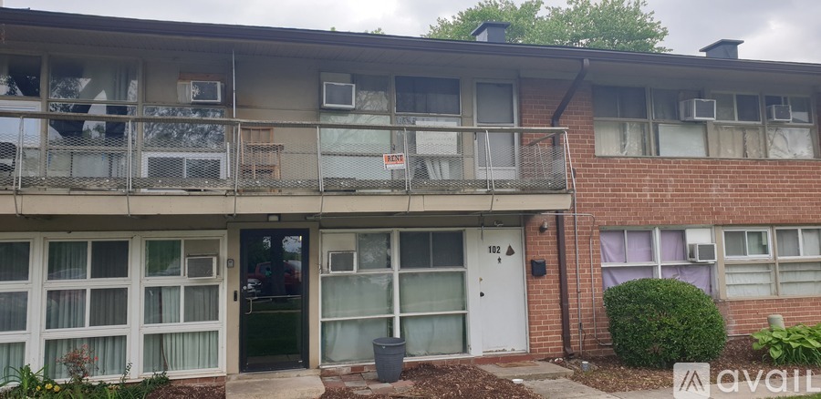 Apartment building with a balcony and a door with a sign on it.