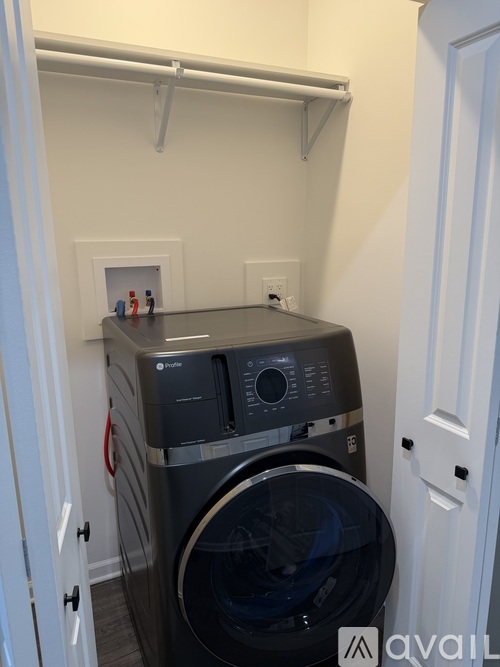A black front loading washing machine in a small laundry room.