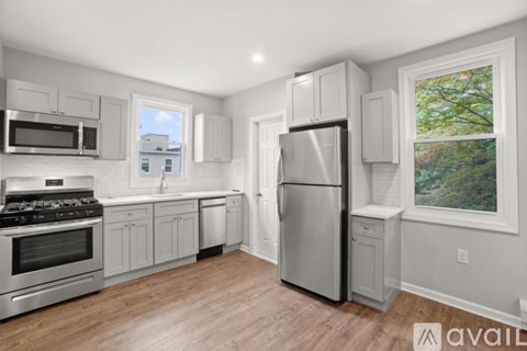 A kitchen with a refrigerator, stove, and microwave.